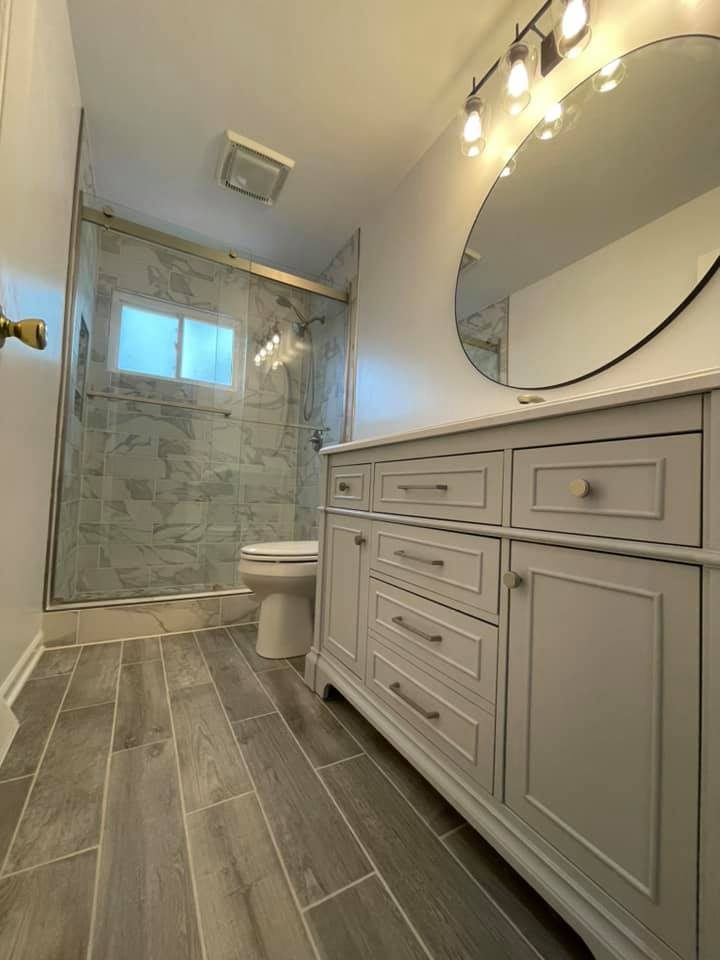 Fully remodeled bathroom with marble-tile shower and modern vanity